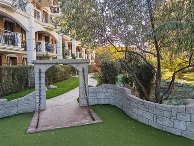 an archway in a retaining wall in a yard at Harmony Suitеs apartment in Sunny Beach