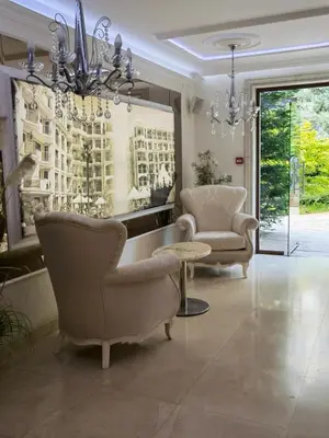 a living room with two chairs and a chandelier at Harmony Suitеs apartment in Sunny Beach