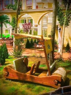 a wooden boat sitting in the grass in front of a house at Sunny studio in Sweet Home Complex in Sunny Beach