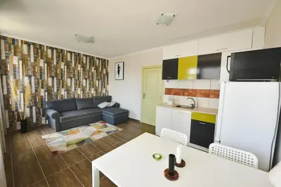 a kitchen and living room with a couch and a refrigerator at Apartments SunWave Saint Vlas in Sveti Vlas