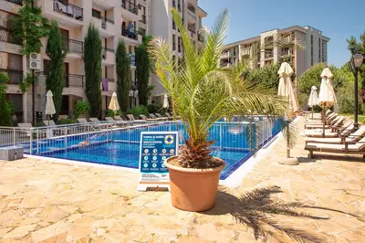 a plant in a pot next to a swimming pool at Cascadas Holiday Apartments in Sunny Beach