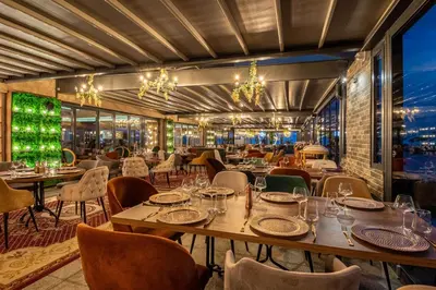 a restaurant with tables and chairs and chandeliers at Paradiso Dreams Hotel in Nesebar