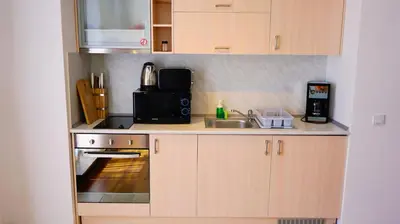 a small kitchen with a sink and a microwave at Byala Cliff Sea View Penthouse in Byala