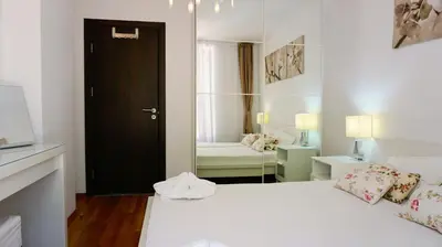 a bedroom with a white bed and a black door at Byala Cliff Sea View Penthouse in Byala