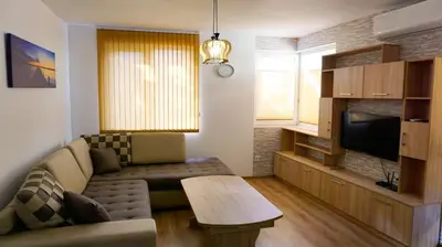 a living room with a couch and a tv at Апартамент Далия - Apartment Dalia in Varna City