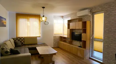 a living room with a couch and a tv at Апартамент Далия - Apartment Dalia in Varna City
