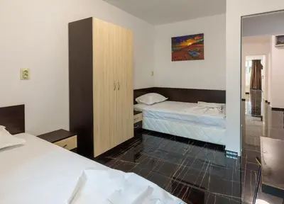 a hotel room with two beds and a cabinet at Стаи за гости ПИРОТСКА 39 in Burgas City