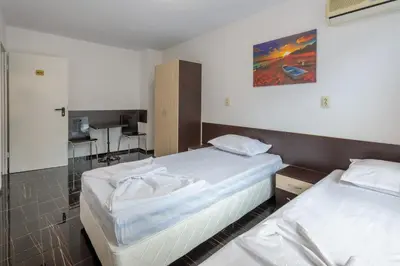 a room with two beds and a desk at Стаи за гости ПИРОТСКА 39 in Burgas City