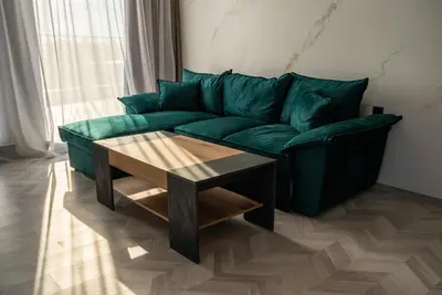a green couch in a living room with a coffee table at хотел ADDRESS in Ravda