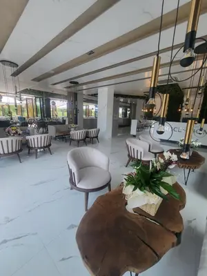 a lobby with chairs and a table with flowers on it at хотел ADDRESS in Ravda