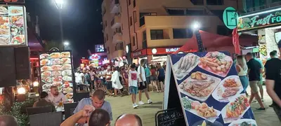 a crowd of people walking on a street at night at Apartmány Rose Residence Nesebar in Sunny Beach