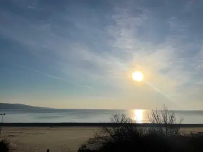 a view of a beach with the sun in the sky at Apart hotel Gallery A in Sunny Beach