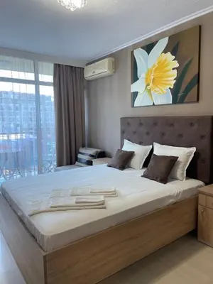 a large bed in a bedroom with a large window at Apart hotel Gallery L in Sunny Beach