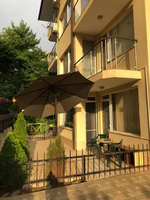 a patio with an umbrella in front of a building at Apartmán Katka, Obzor in Obzor