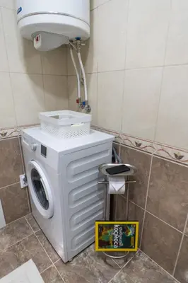 a washing machine in a bathroom with a sign on the floor at Sea grape wine flat in old center in Varna City