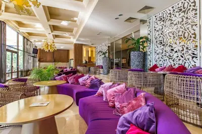 a restaurant with purple couches and tables in a room at ROYAL BEACH & APARTAMENT in Sunny Beach