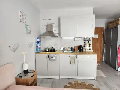 a small kitchen with white cabinets and a sink at Joy Apartment Sunny Beach in Sunny Beach