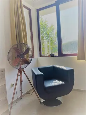 a room with a fan and a chair and a fan at Villa Rada, Bay View Villas in Kosharitsa