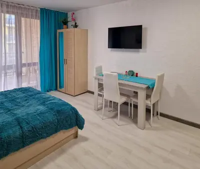 a bedroom with a table and chairs and a bed at Апарткомплекс Амара Слънчев Бряг Студио 13 in Sunny Beach