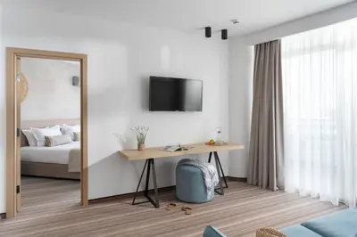 a bedroom with a bed and a table and a mirror at PERLA TUI SUNEO All inclusive in Sunny Beach