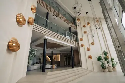 a hallway of a building with potted plants and chandeliers at PERLA TUI SUNEO All inclusive in Sunny Beach