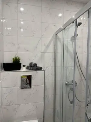 a bathroom with a shower with a glass door at Studio Marrone on Bogoridi in Burgas City
