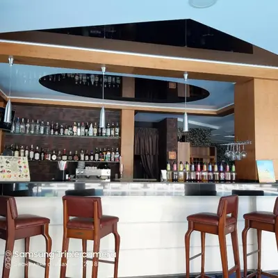 a bar with chairs and a counter with liquor bottles at Studio Milenium in Pomorie