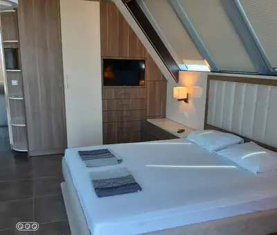 a large white bed in a room with a television at Studio Milenium in Pomorie