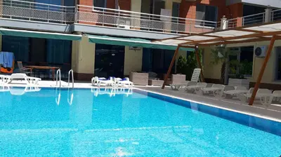 a large swimming pool with chairs and a hotel at Studio Milenium in Pomorie