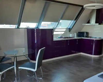 a kitchen with purple cabinets and a table and chairs at Studio Milenium in Pomorie