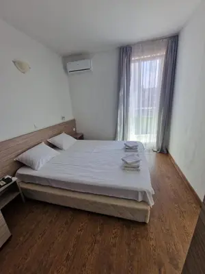 a bedroom with a large bed and a window at Апартамент СаMи in Burgas City
