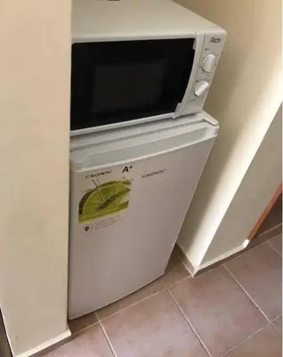 a microwave oven sitting on top of a refrigerator at Cosy, Studio Apartment At Nesebar Fort Club in Sunny Beach