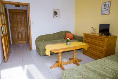 a living room with a couch and a table at Panorama Chantall-izby,apartmány s výhľadom na more in Ravda