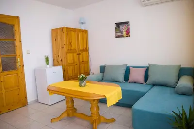 a living room with a blue couch and a table at Panorama Chantall-izby,apartmány s výhľadom na more in Ravda