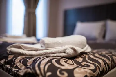 a pile of towels sitting on top of a bed at Varna Central Ohrid 2bdr Apartment in Varna City