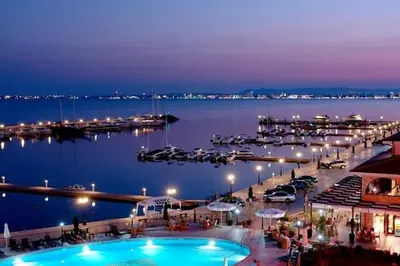 a view of a marina at night with a pool at Royal Palm Studio with Seaview in Sveti Vlas