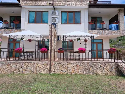 a building with tables and umbrellas in front of it at Buongiorno! Premium in Sveti Vlas