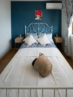 a bedroom with a white bed with a blue wall at Buongiorno! Premium in Sveti Vlas