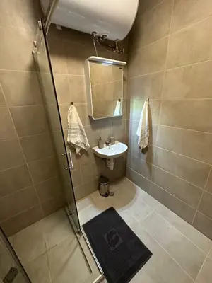 a bathroom with a shower and a sink and a mirror at Cosy apartments with sea view in complex PANORAMA in Chernomorets