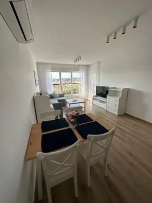 a white living room with a table and chairs at Cosy apartments with sea view in complex PANORAMA in Chernomorets