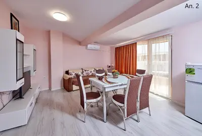 a dining room with a table and chairs in a room at Апартаменти Боряна in Pomorie