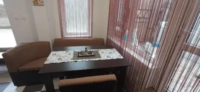 a dining room table with two chairs and a table with a plate on it at Апартамент с две спални. in Varna City