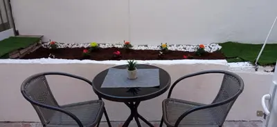 a table with two chairs and a table with a plant at Апартамент с две спални. in Varna City