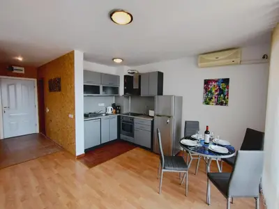 a kitchen and dining room with a table and chairs at Apartament Panorama - BastetBS in Sveti Vlas