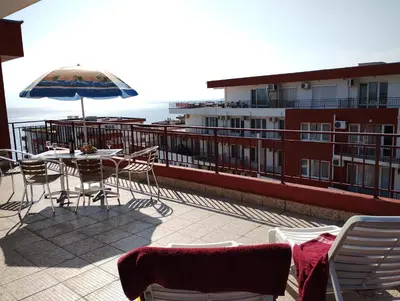 a patio with a table and chairs and an umbrella at Apartament Panorama - BastetBS in Sveti Vlas