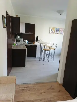 a kitchen with a table and chairs in a room at Созопол Дриймс FSM Апартамент in Sozopol