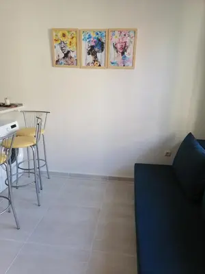 a living room with a blue couch and a table at Созопол Дриймс FSM Апартамент in Sozopol
