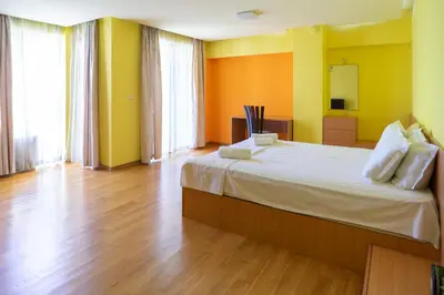 a bedroom with a large bed with yellow and orange walls at Central flat with Monster living room in Varna City