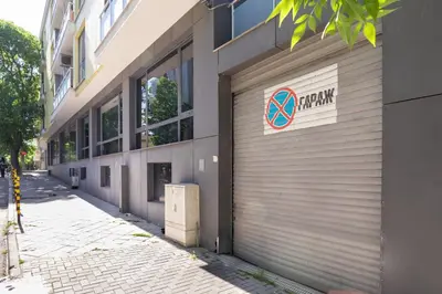 a garage door of a building with a sign on it at Central flat with Monster living room in Varna City