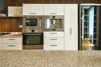 a kitchen with white cabinets and stainless steel appliances at Central flat with Monster living room in Varna City